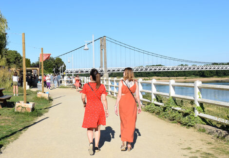 Deux jeunes femmes, de dos, se promenant au jardin de l'Eperon, vers le pont