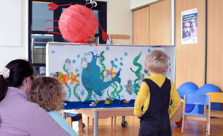 Des enfants et une assistante maternelle dans la salle de motricité du Relais Petite Enfance