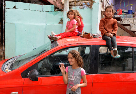 Des fillettes palestiniennes de moins de 5 ans assises sur une voiture rouge. Une autre, 9 ans environ, devant la voiture.