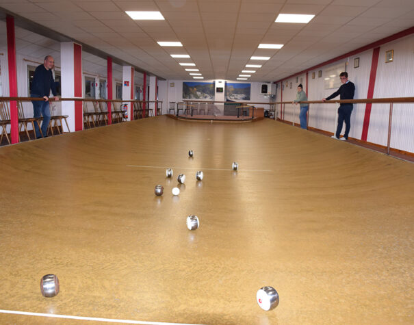 Terrain de boule de fort avec quelques boules au milieu et des spectateurs de chaque côté