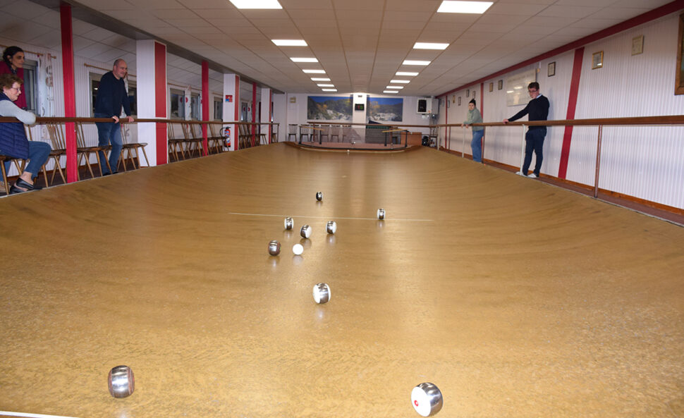 Terrain de boule de fort avec quelques boules au milieu et des spectateurs de chaque côté